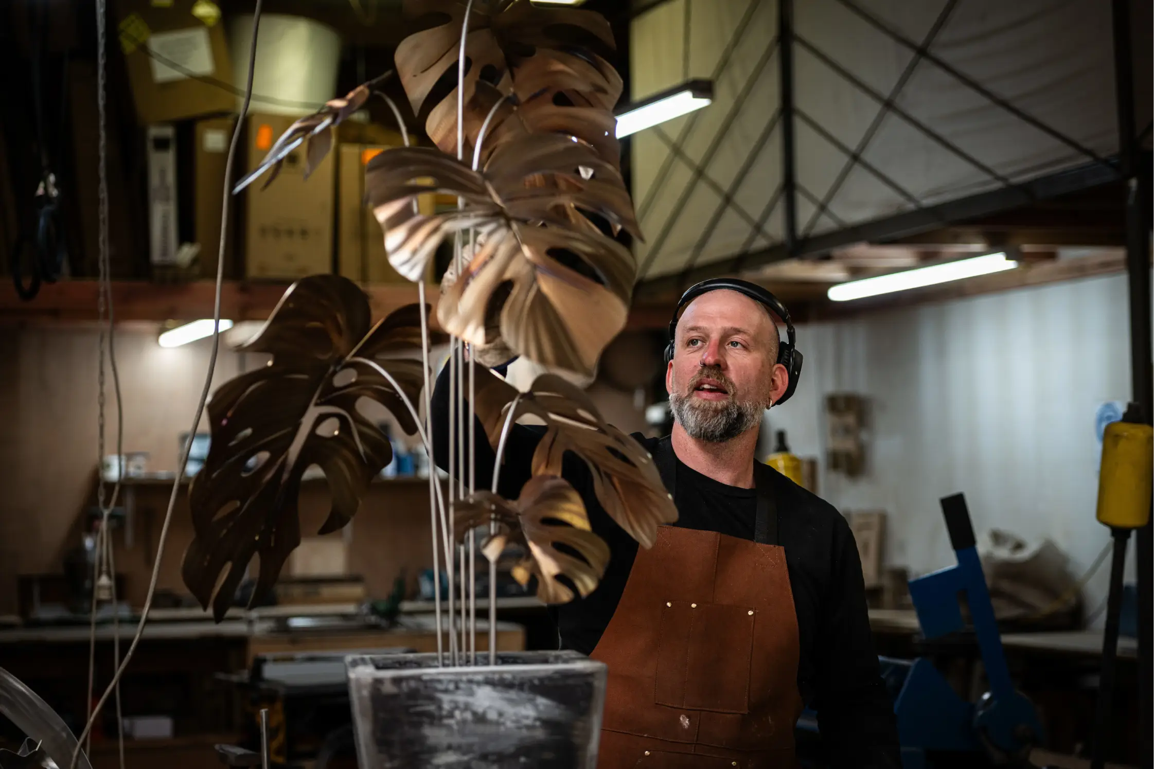 Artist with completed monstera sculpture